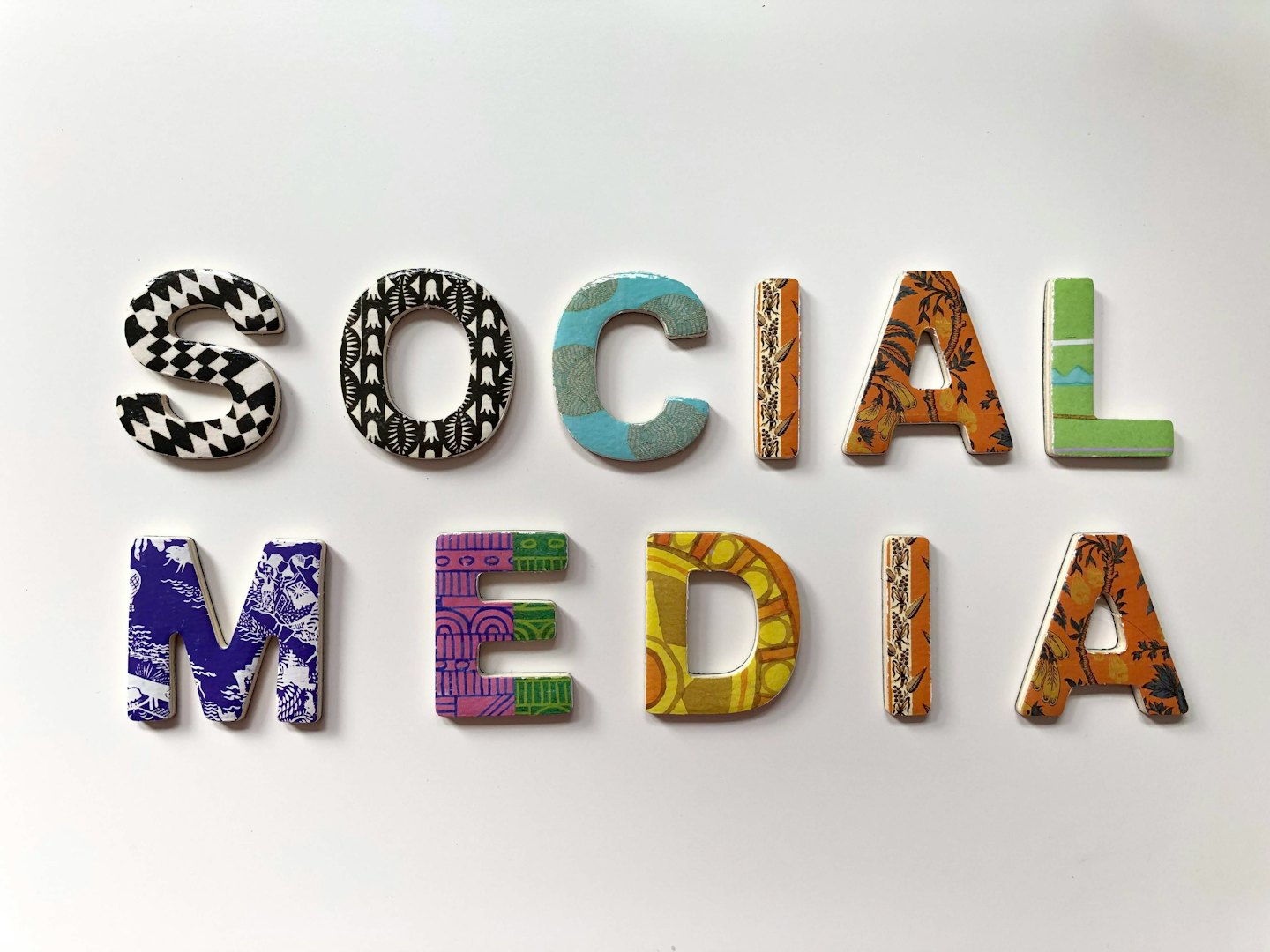 Lettere tridimensionali compongono la scritta SOCIAL MEDIA su sfondo bianco.