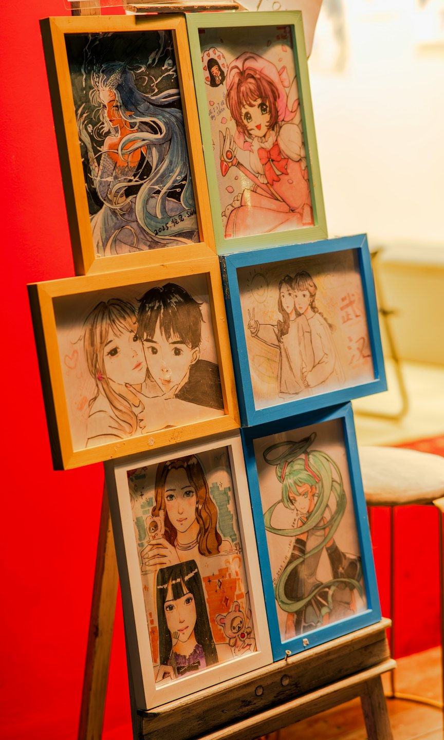Illustrazioni disegnate a mano in stile anime su un cavalletto di legno.